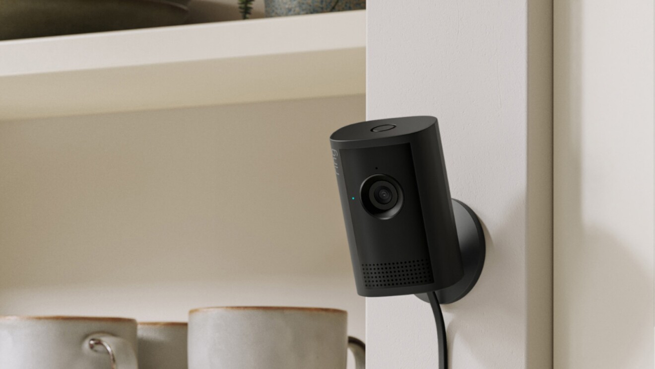 Ring Indoor Camera on a wall next to a kitchen shelf