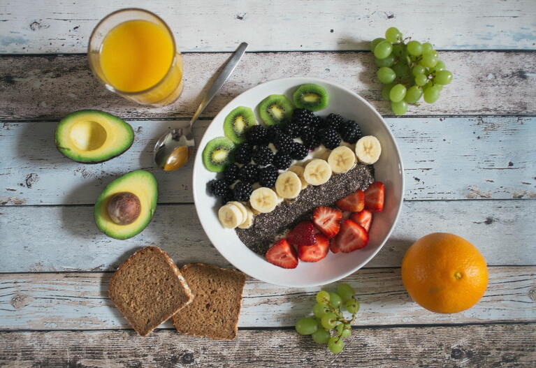 Image of a breakfast table which has fresh fruits, bread and cereals
