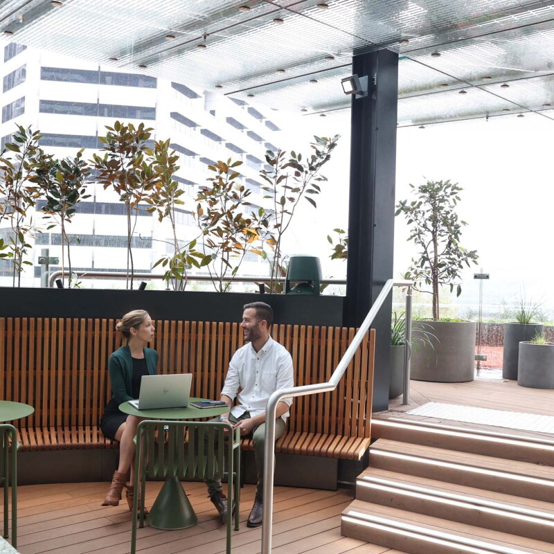 A man and woman who are Amazon employees engage in a conversation in a shared workspace in our Sydney, Australia office. 