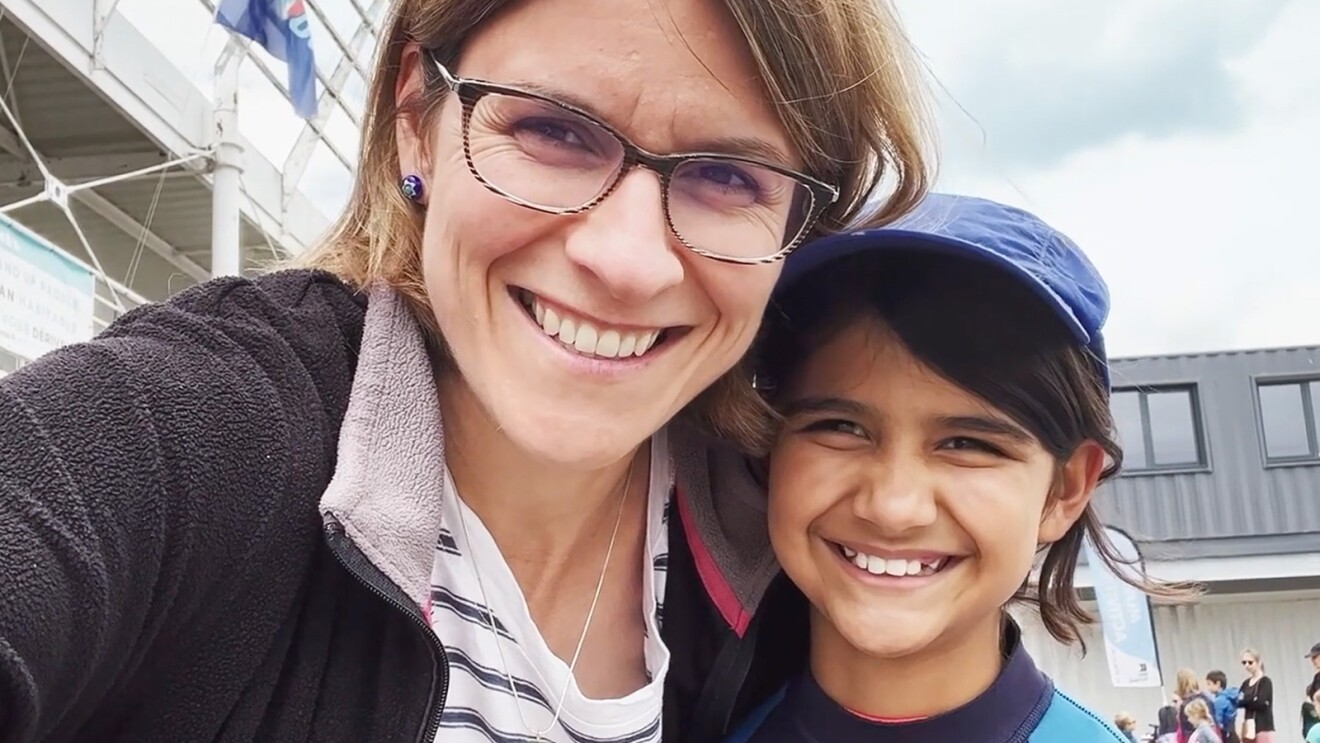 A woman and a kid smiling at the camera taking a selfie. 