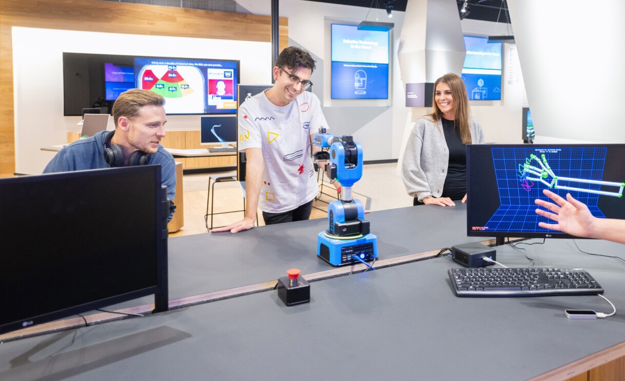 A photo of four people using a robot inside the AWS Skills Center in Arlington, Virginia.