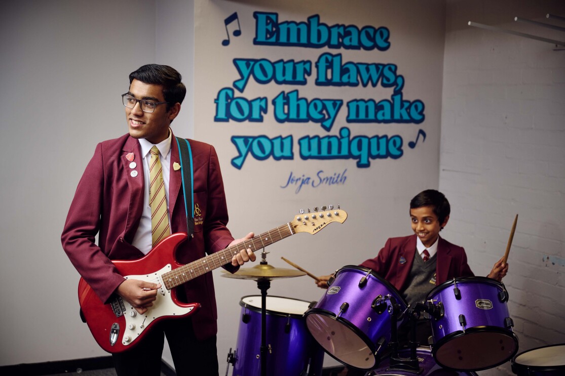 School students play music in front of a quote by Jorja Smith