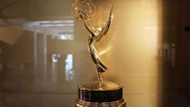 大きな円で作られた球体をもった翼のある女性をかたどった金色のトロフィがガラスの棚の中に展示されている。