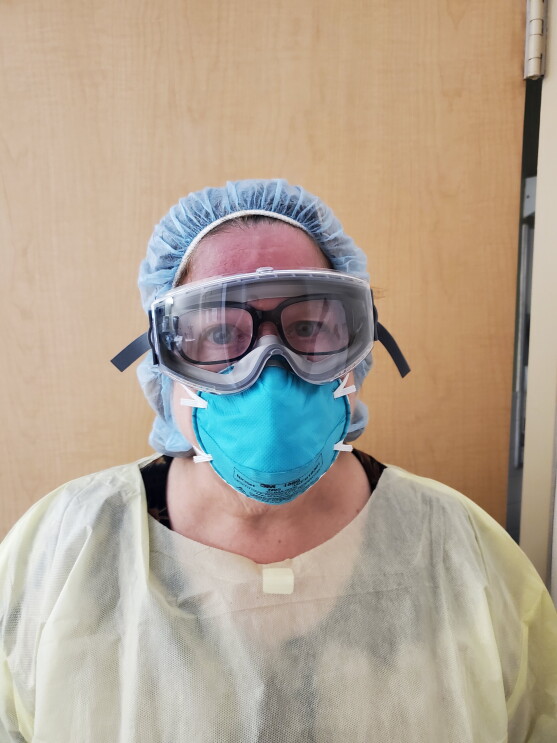 A woman wearing PPE has her Echo Frames on under her goggles, as a Physician's Assistant.
