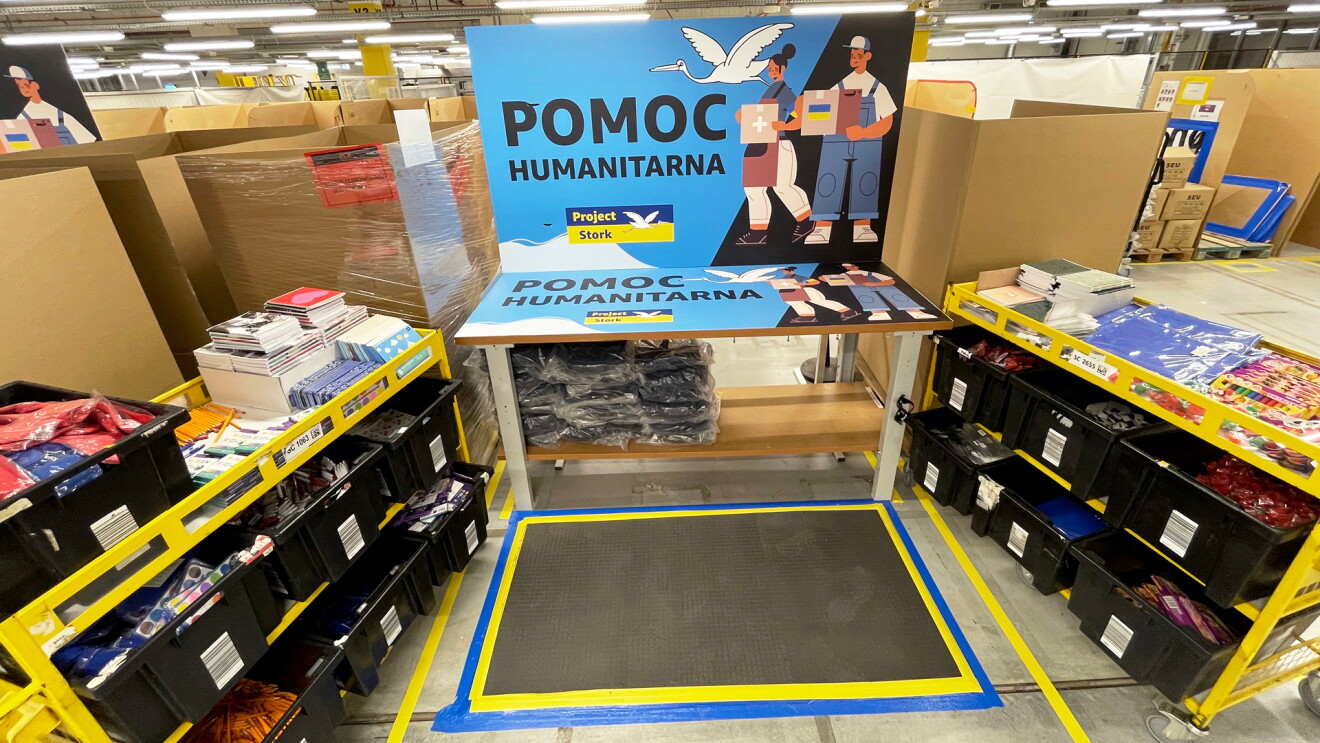 School supplies organized in bins with a sign overhead that reads, "POMOC HUMANITARNA." 