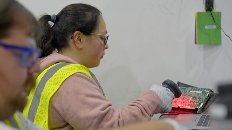 A photo of a technician scanning repaired hardware for shipment. 