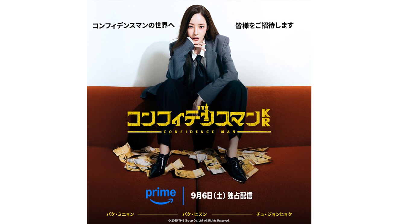 グレーのジャケットにネクタイを締め、黒いパンツ着用の女性が、赤褐色のソファの背もたれ部分に腰かけ、座面に散らばった紙幣を黒い靴で踏んでいる。中央に黄色い文字で「コンフィデンスマンKR」。