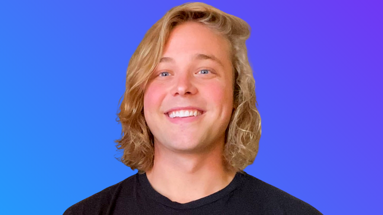 A headshot image of Kory Kelly wearing a shirt that says "Legal Karma" and smiling for a the photo in front of a blue background.
