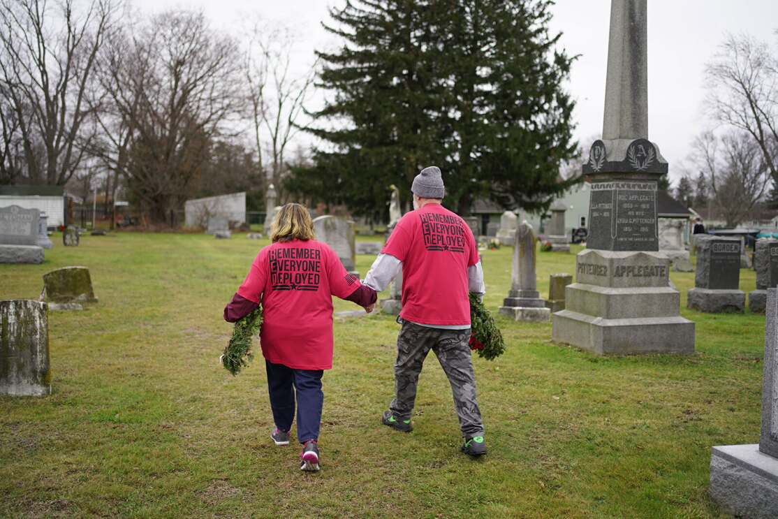 An image of Warriors@ members placing wreathes and flags on veterans' graves.