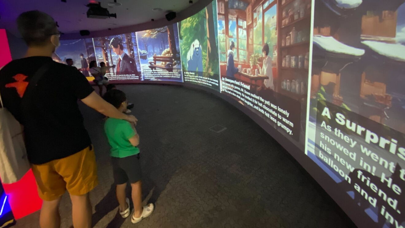 A man and a boy experiencing StoryGen at the Central Public Library in Singapore.