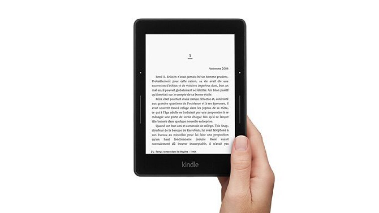 Une main de femme tient une lieuse Kindle sur laquelle s'affiche le premier chapitre d'un livre