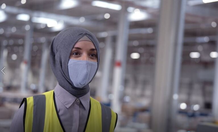 Eine Frau in Kopftuch und Maske.