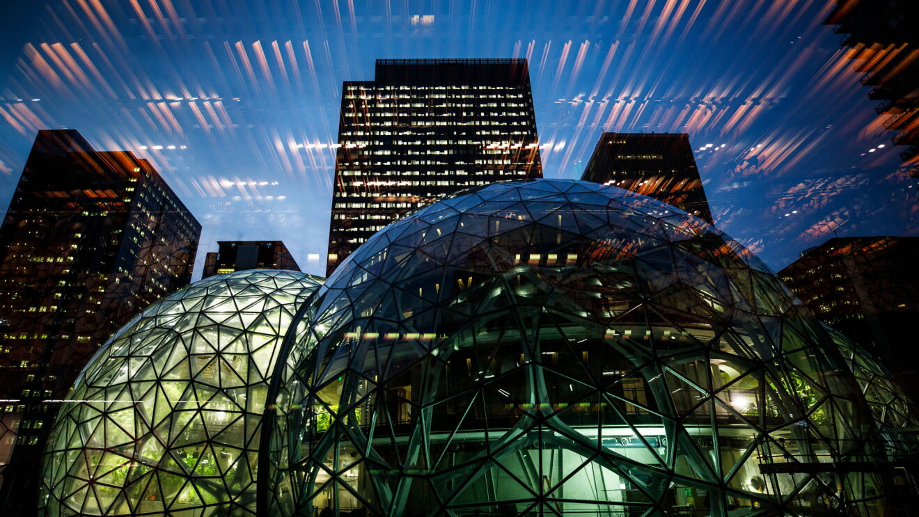 Amazon Spheres lit up at night, with lighting reflection in the glass. 