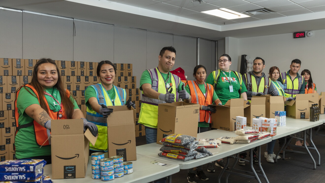 Trabajadores de un centro logístico de Amazon preparando comida para donar. 