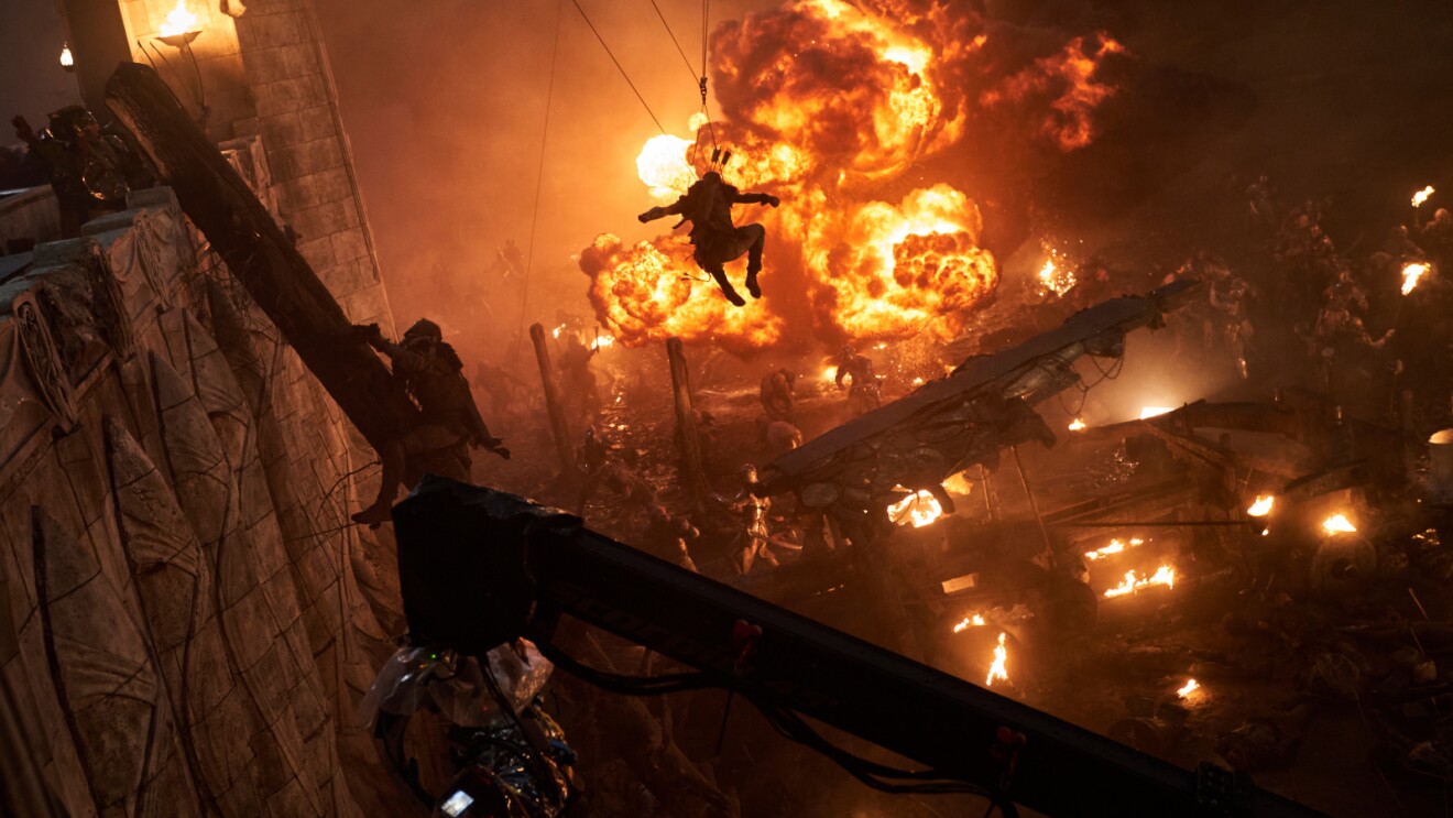 Silhouette leaps through fiery explosion in chaotic action scene