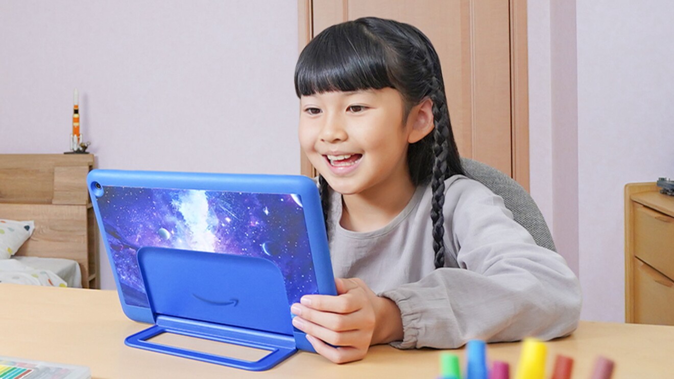 机でAmazonKidsタブレットを見ている少女