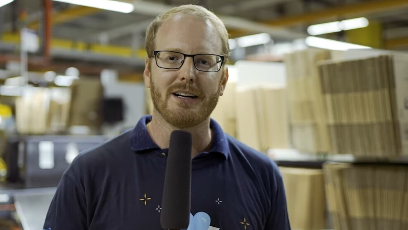 Ein Mann im Amazon T-Shirt, der ein Mikro in der Hand hält.
