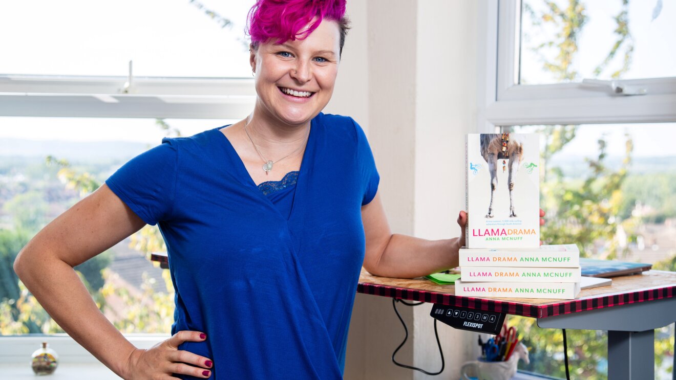 Author Anna McNuff showing her award-winning book Llama Drama