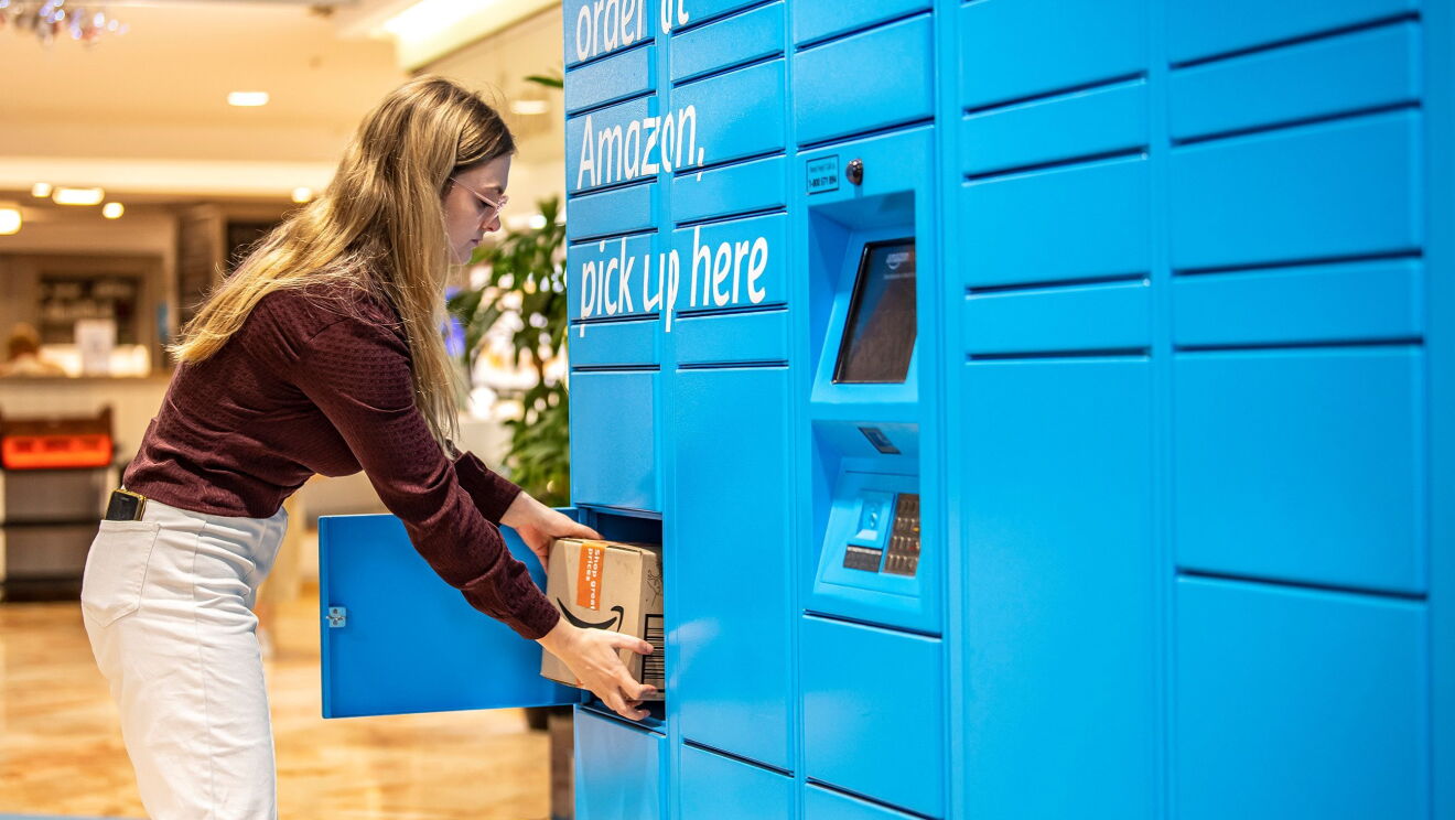 A woman in red wine shirt is picking up a package from Amazon Locker