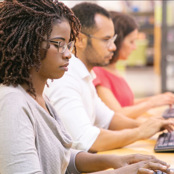 Tre persone di profilo digitano ai loro computer