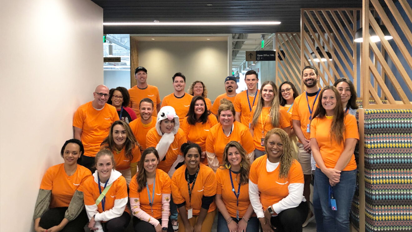 A group of Amazon volunteers wear orange T-shirts.
