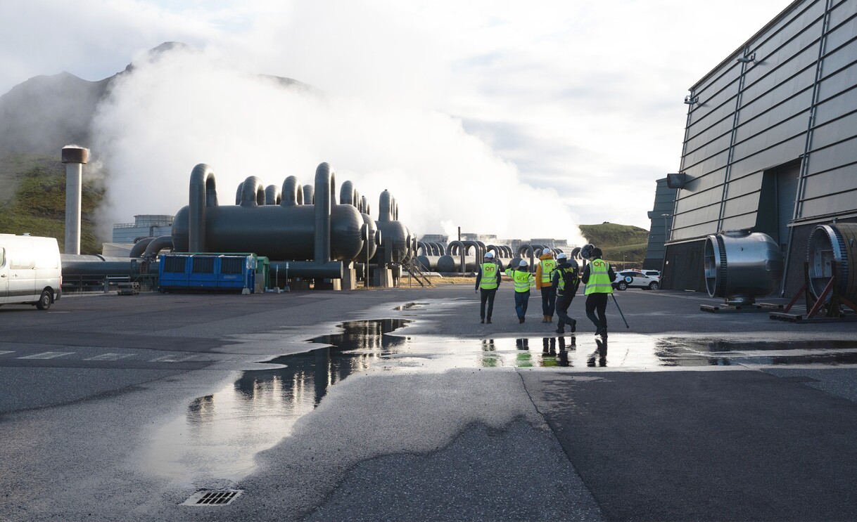 An image of people with neon vests walking to geothermal plants in Iceland.