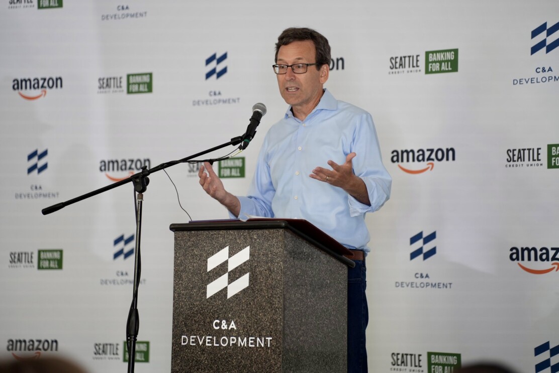 Washington state Governor Bob Ferguson stands behind a podium speaking to an audience not in photo