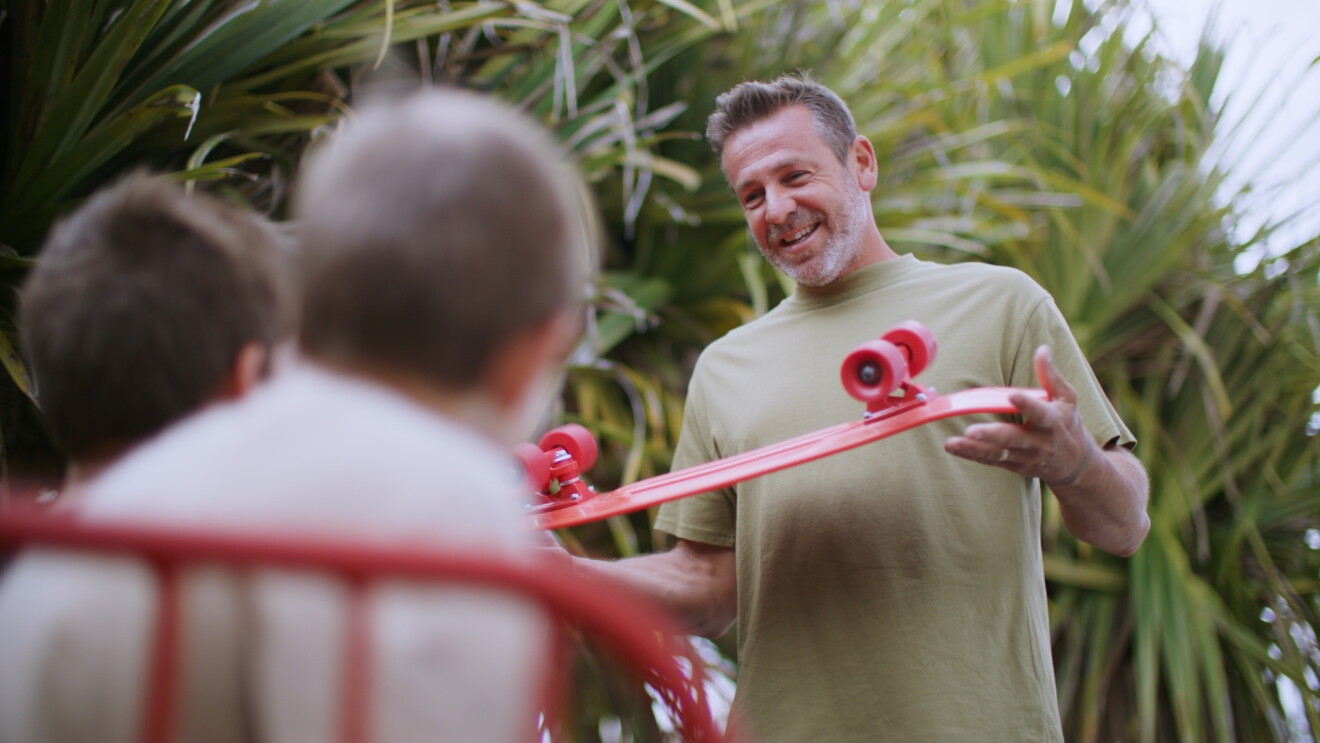 Penny skateboards founder showing skateboard to kids