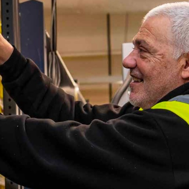 An over-55 person picking goods in an Amazon warehouse.