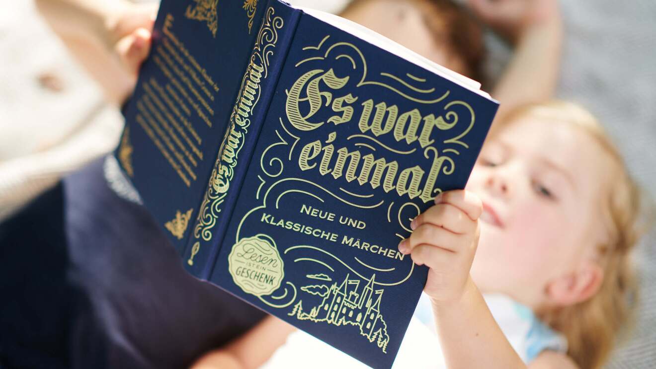 Zwei Kinder lesen zusammen in einem Märchenbuch