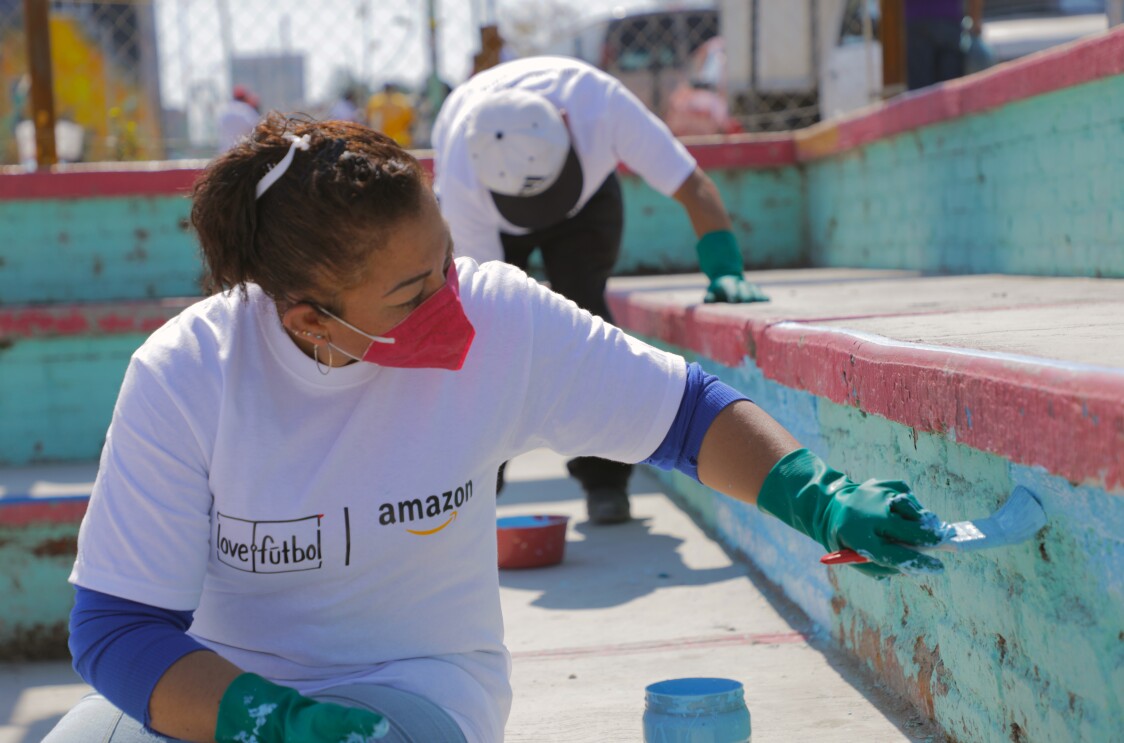 Voluntario de Amazon remodelando una cancha de fútbol. 