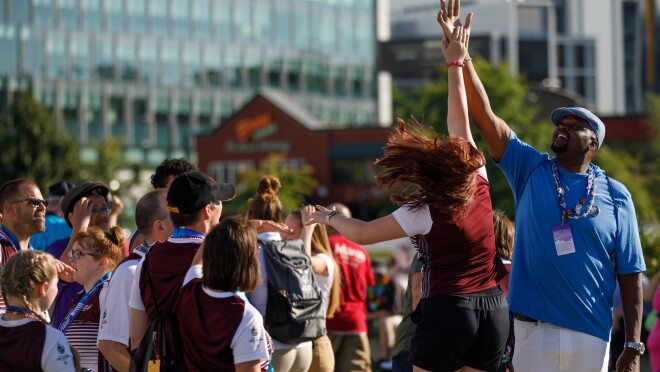 高5给出特殊奥运会闭幕式。发生击掌,一个女人跳起来达到男性志愿者的手的手。