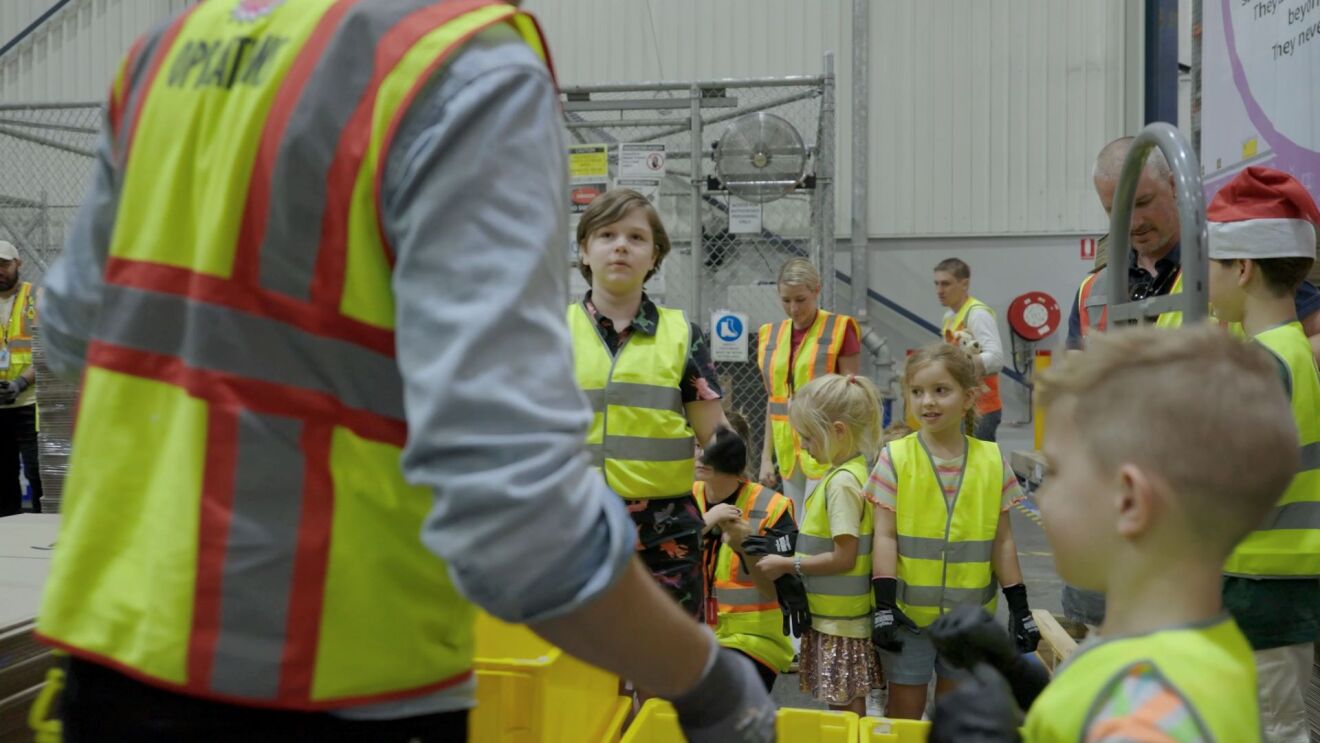 a boy is looking at the man explaining something in Amazon fulfillment centre