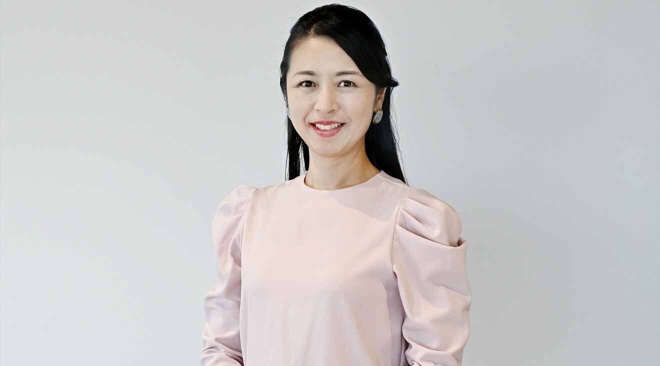 ピンク色のブラウスを着たロングヘアの女性