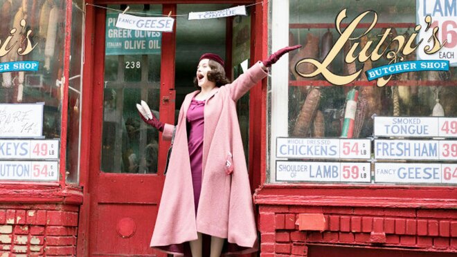 An image of Midge Maisel standing in the entryway of Lutzi's butcher shop in a scene from the marvelous mrs. maisel