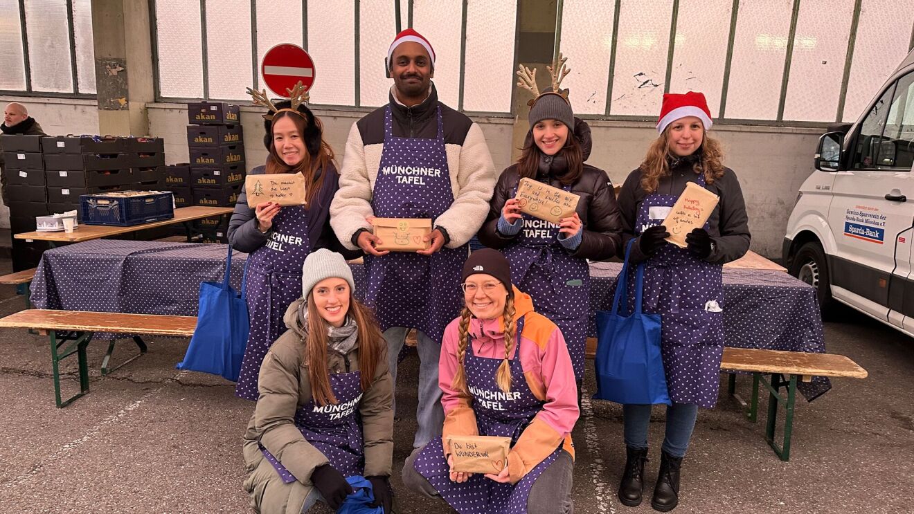 In München halfen Mitarbeiter:innen dabei die Lebensmittelpakete an Gäste der Münchner Tafel auszugeben.