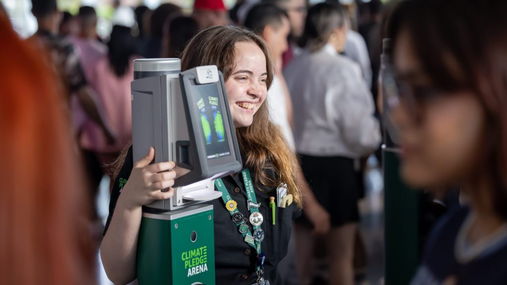 An image of a woman smiling while standing next to a ticket scanner