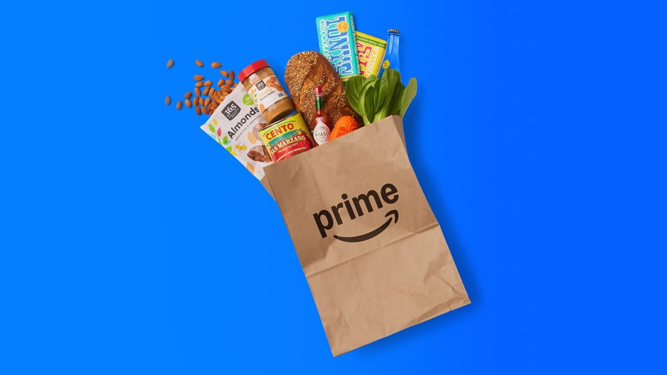 Brown paper Prime bag filled with groceries against vibrant blue backdrop