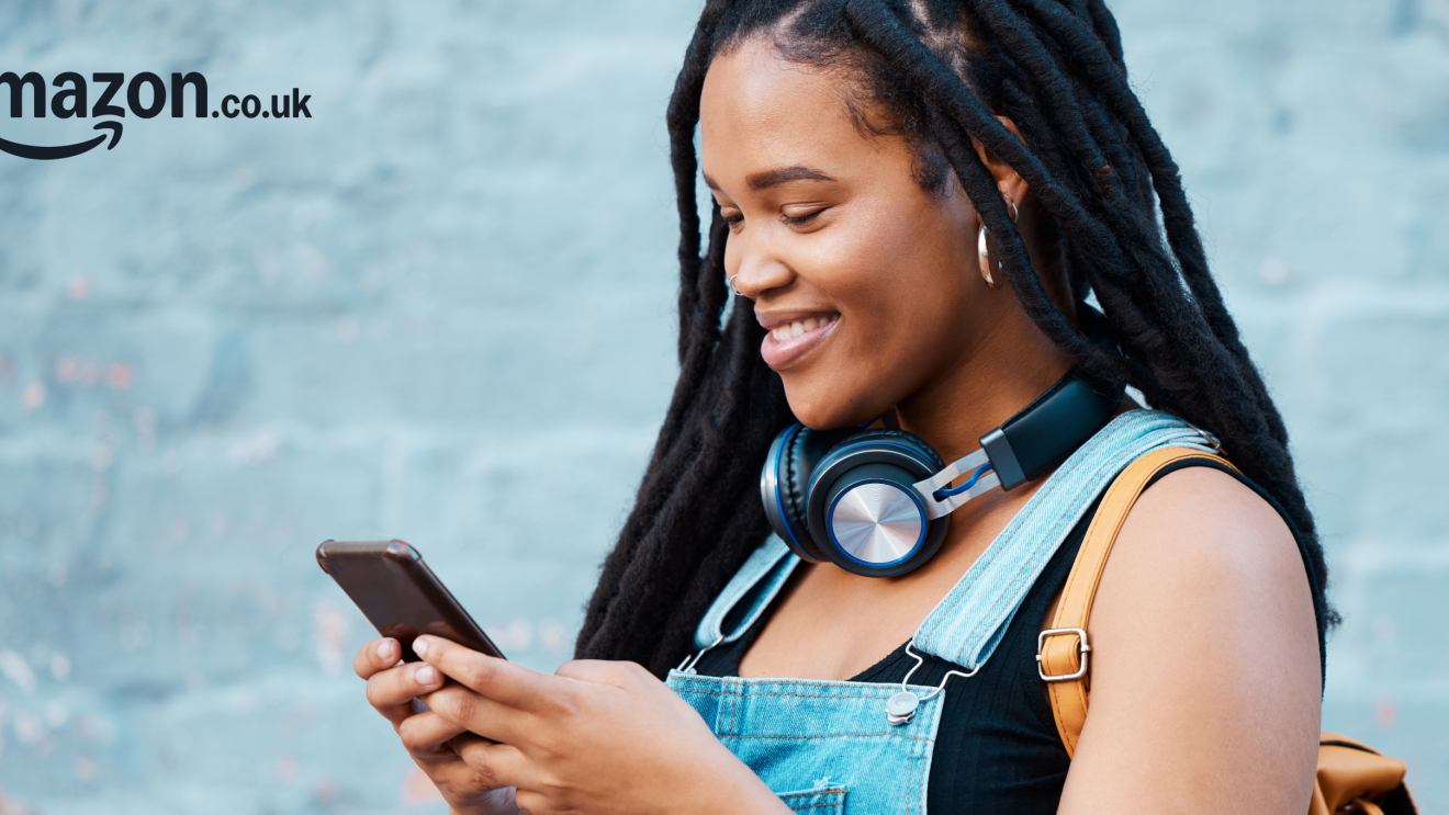 A girl smiling as she looks down on her phone