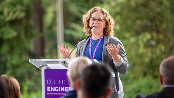 Alice Shobe stands behind a podium as speaks to a crowd and announces Amazon's $5 million donation to University of Washington's Interdisciplinary Engineering Building at the facility's groundbreaking ceremony.