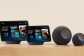 Four Amazon Echo devices of varying sizes displayed on wooden surface
