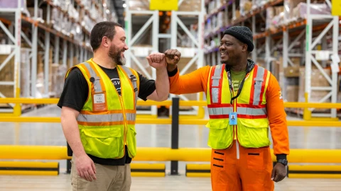 two amazon employees fist bumping 