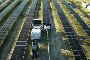Overhead shot of workers at a solar power station working with AI-powered robot