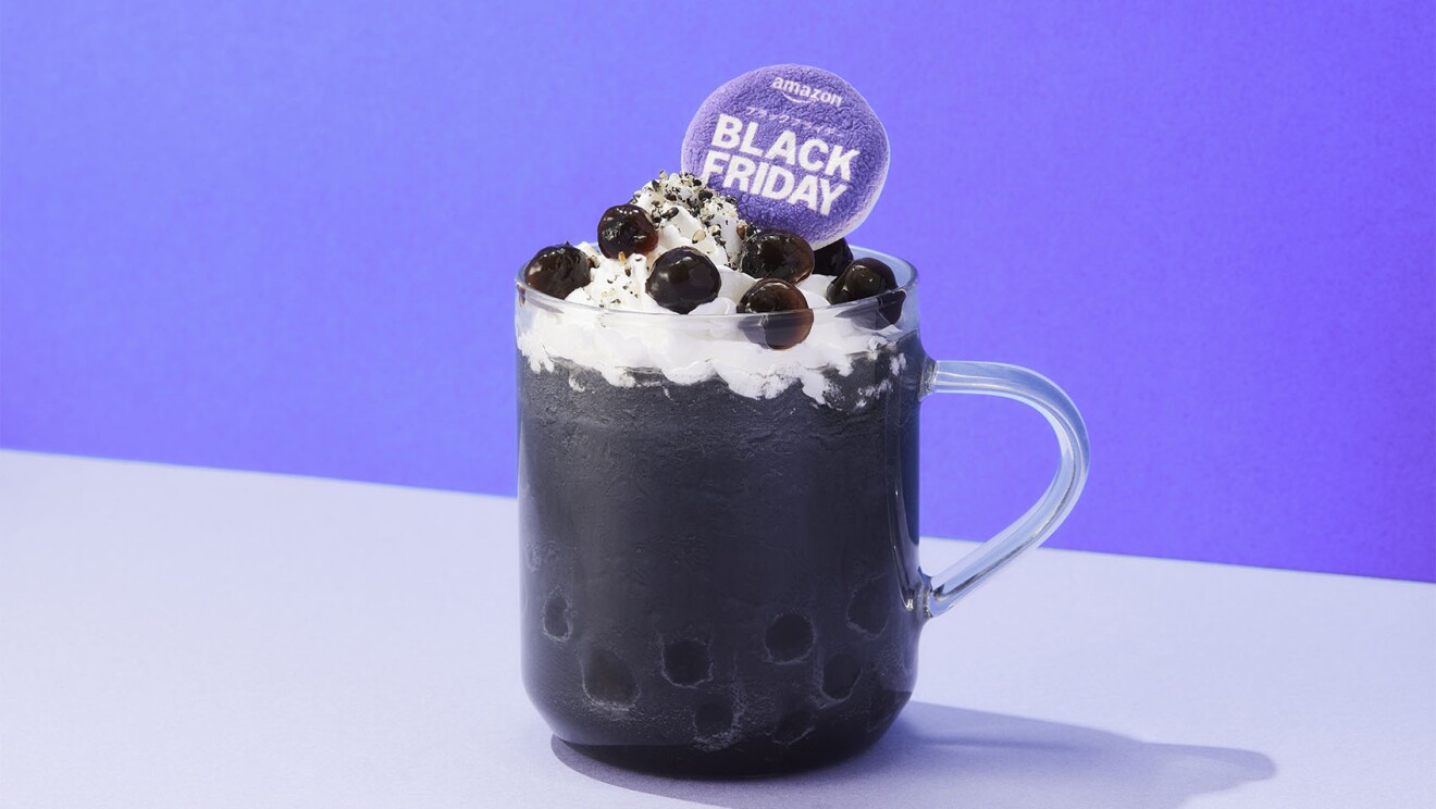 ガラスのマグカップに黒いドリンクが入り、その上にホイップクリームと黒いタピオカが載っている Black Fridayと書かれたカード
