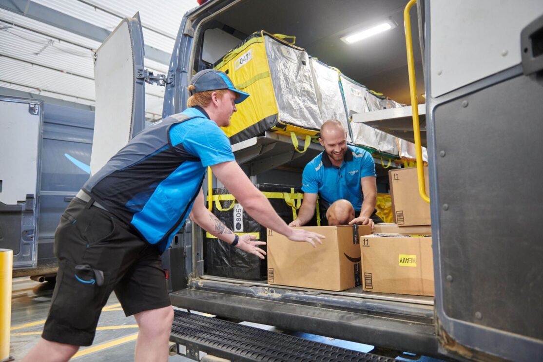 Amazon delivery employees loading packages into an Amazon vehicle