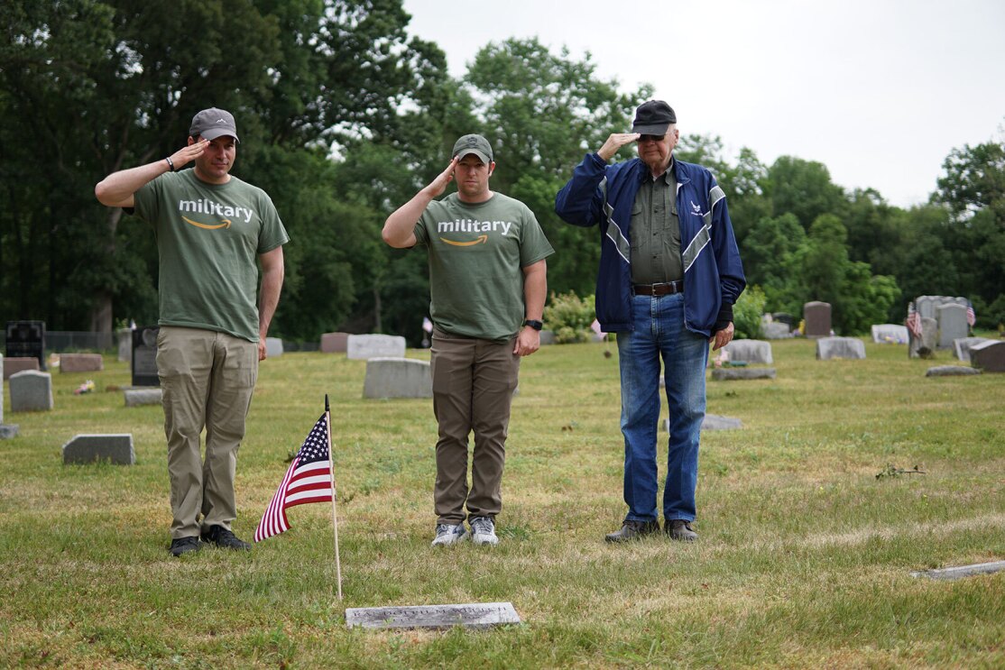 An image of Warriors@ members placing wreathes and flags on veterans' graves.