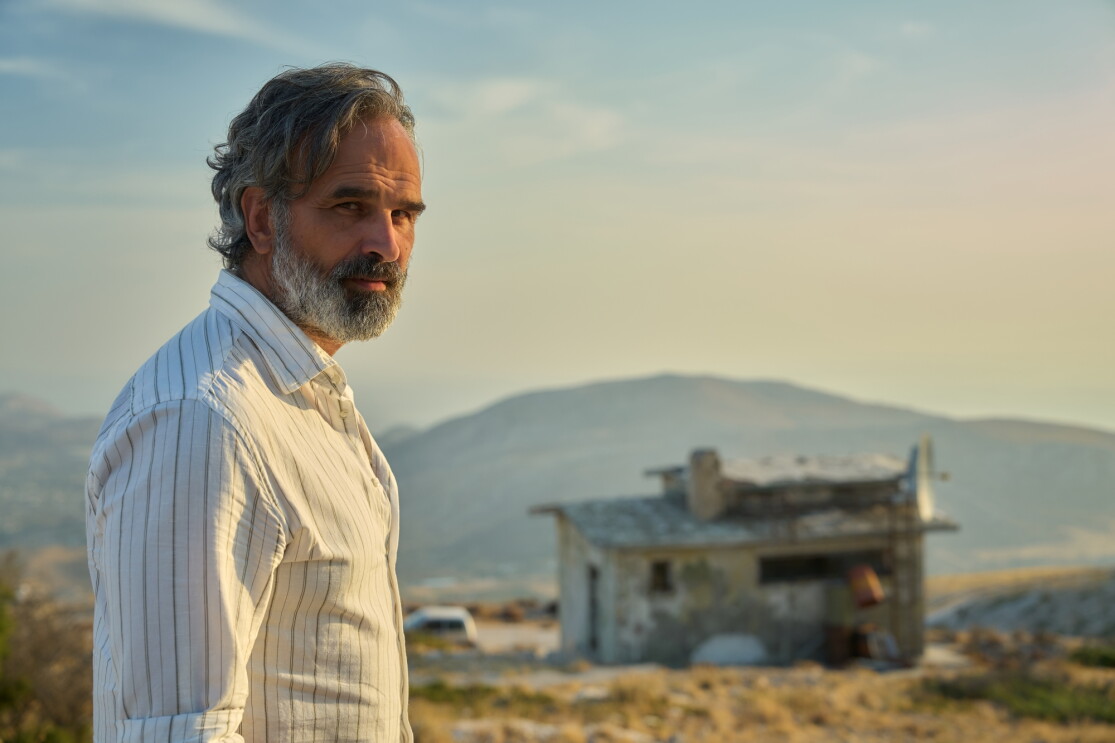 Bearded man in white shirt overlooking arid landscape