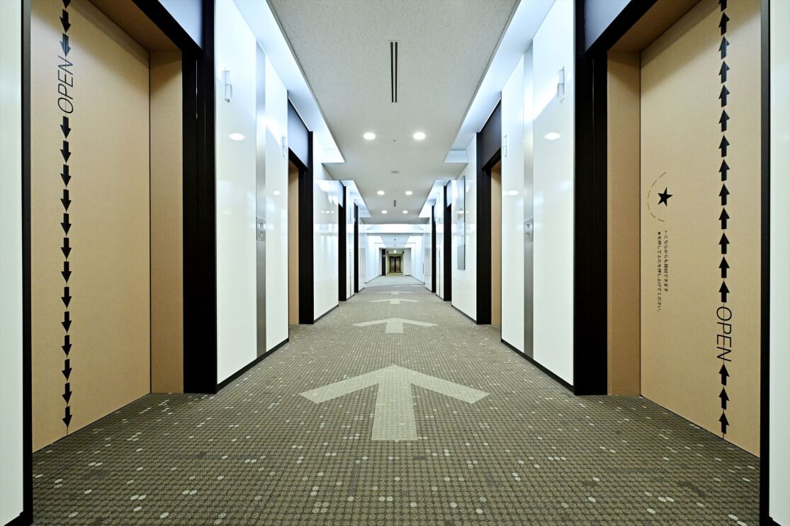 エレベーターホールのカーペットに描かれている矢印。その両サイドにエレベーター