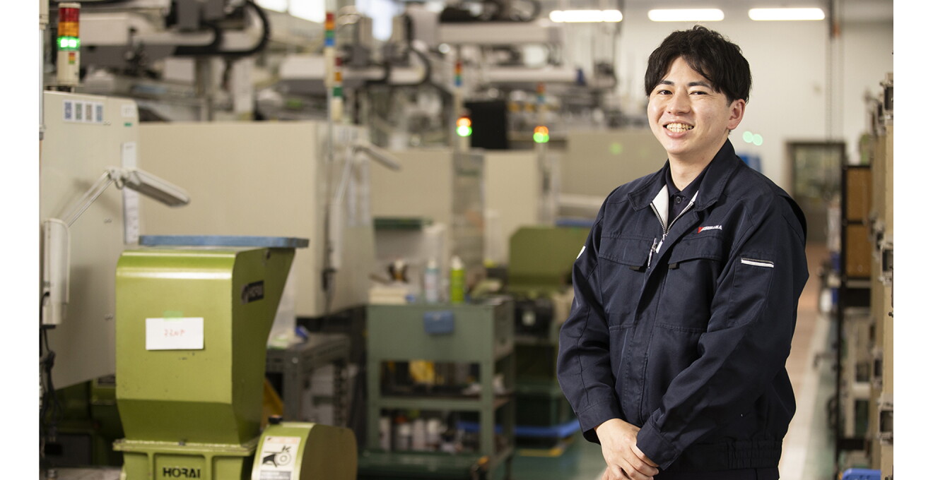 製造現場で笑顔を見せる吉原さんの写真