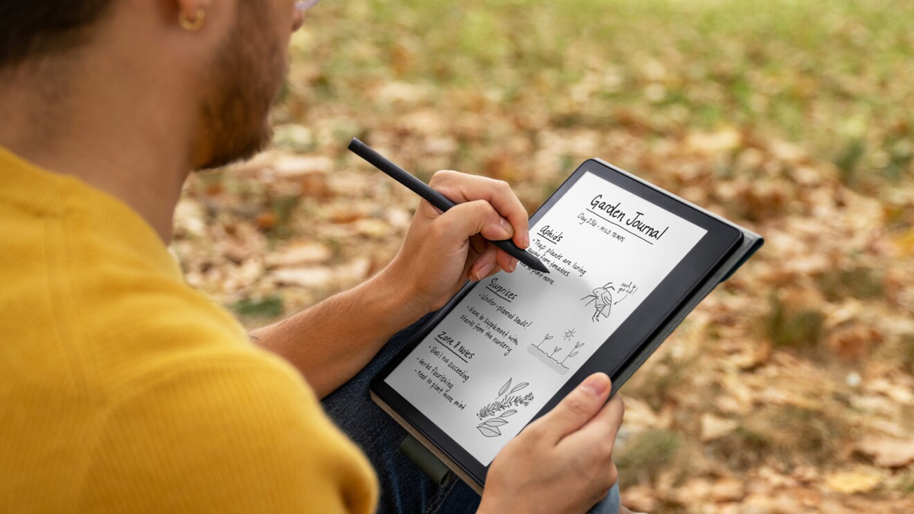 An image of a person wearing a yellow shirt writing on the Kindle Scribe. 